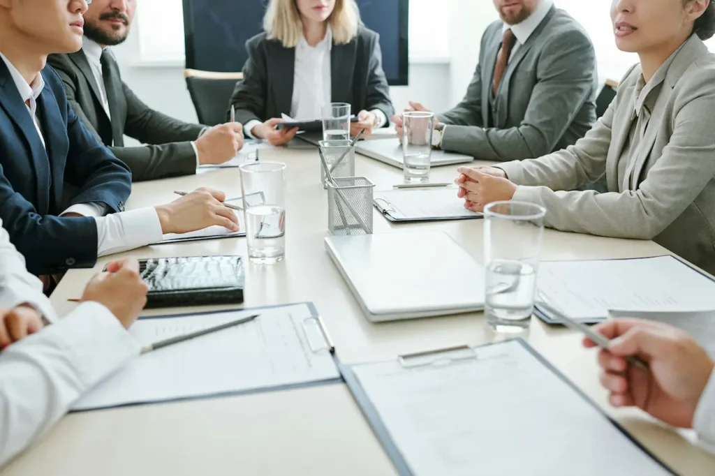 Membres d'un conseil d'administration autour d'une table de conférence avec documents et verres d'eau